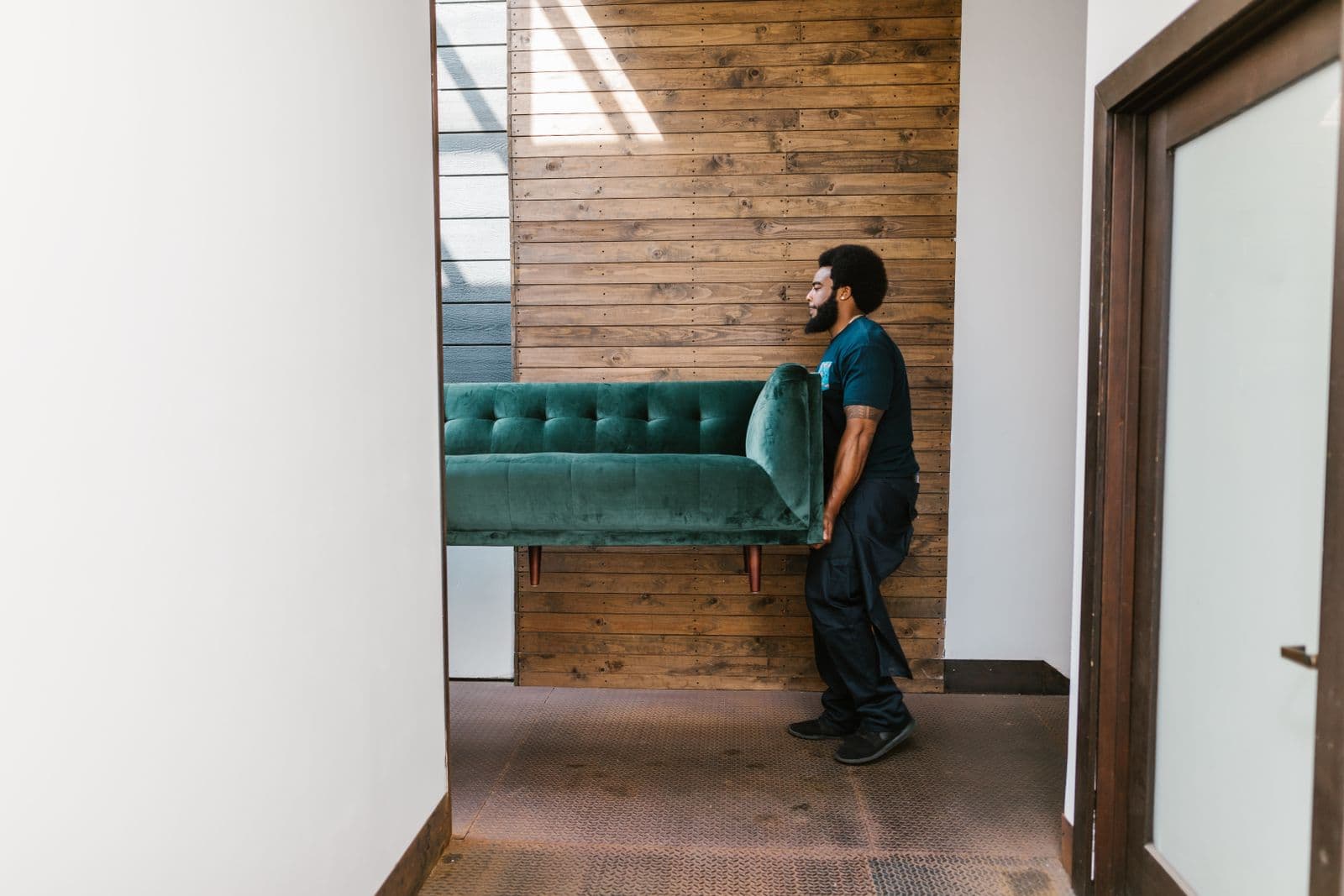 Trained movers carefully carrying a sofa